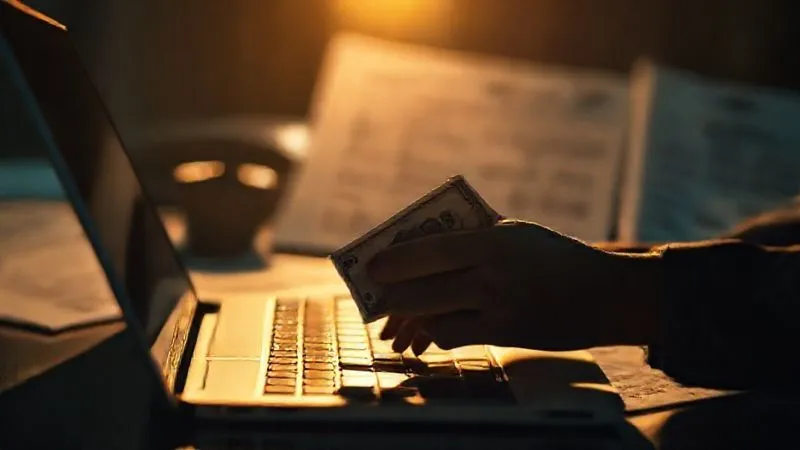 photorealistic, professional photography, 8K, cinematic lighting, sharp focus, depth of field, shot on a high-end DSLR, a shadowy figure subtly moving money between accounts on a laptop, with a blurred backdrop of legal documents, conveying secrecy and financial manipulation
